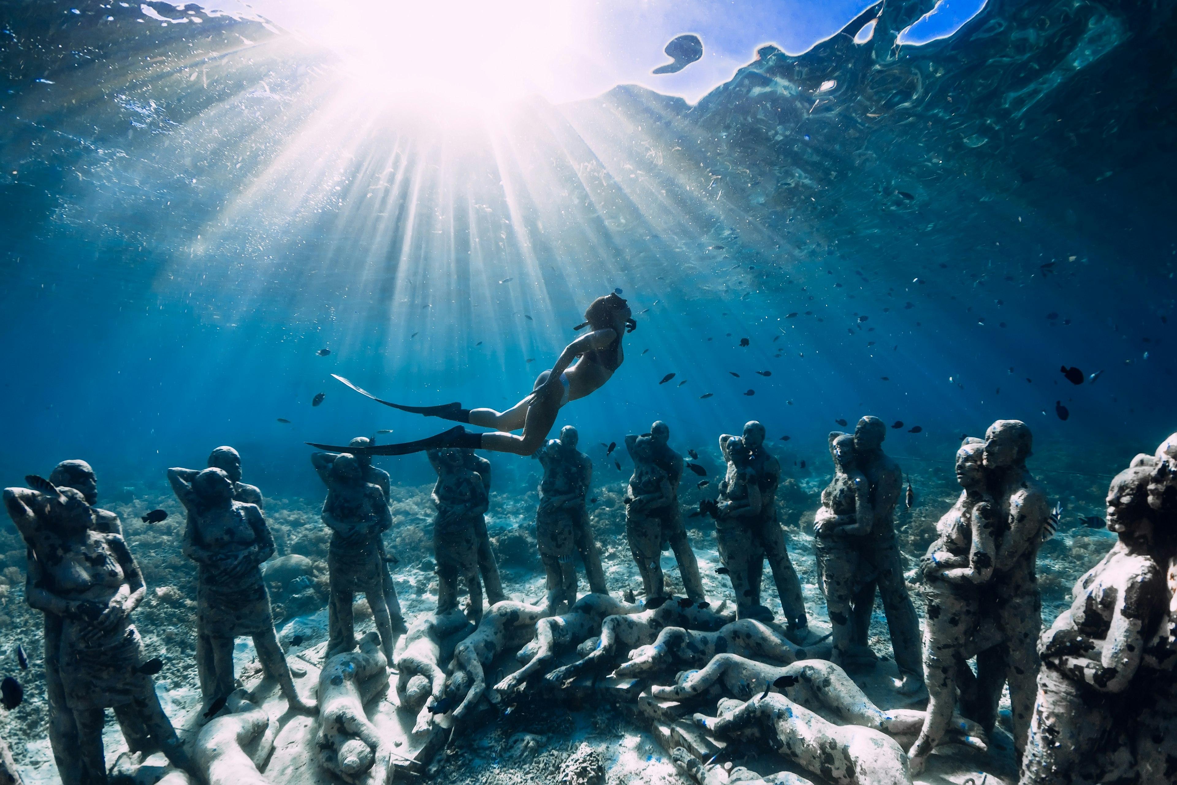 Snorkeler swimming above the underwater statues near Gili Meno